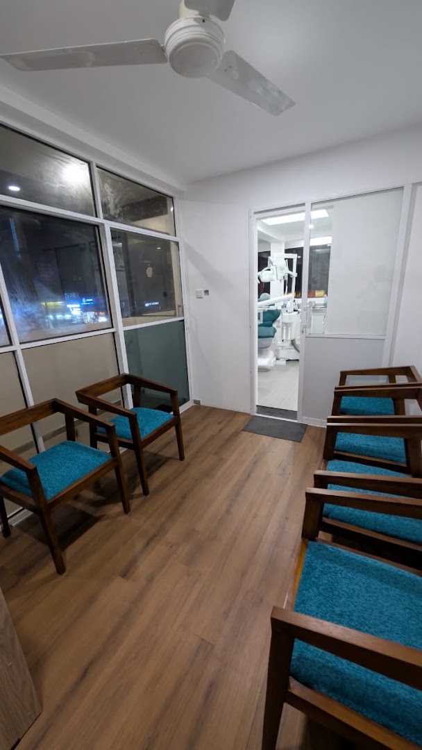 Waiting room with teal upholstered wooden chairs and warm wood flooring